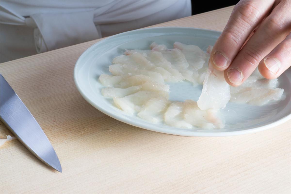 刺身を盛り付けるスタッフ